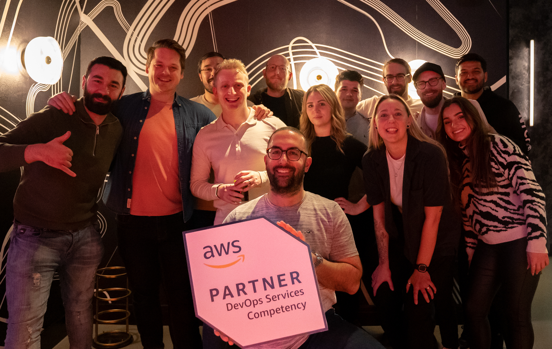 The team celebrating the DevOps competency at F1 Arcade - London